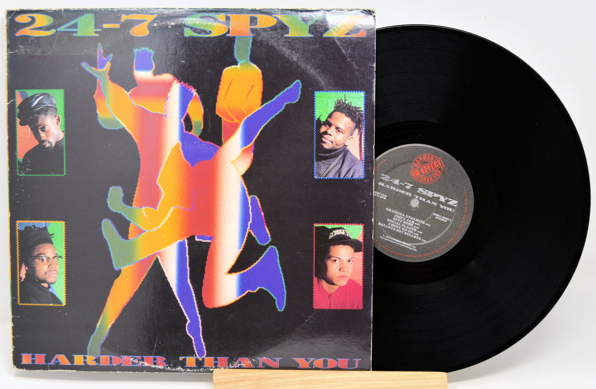 Vinyl record with colorful cover featuring a dancer and faces, on a white background
