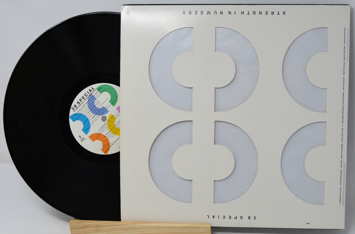A vinyl record partially pulled from its sleeve, photographed on a light background. The sleeve is off-white with large geometric cutout shapes, and the record label reads Special.