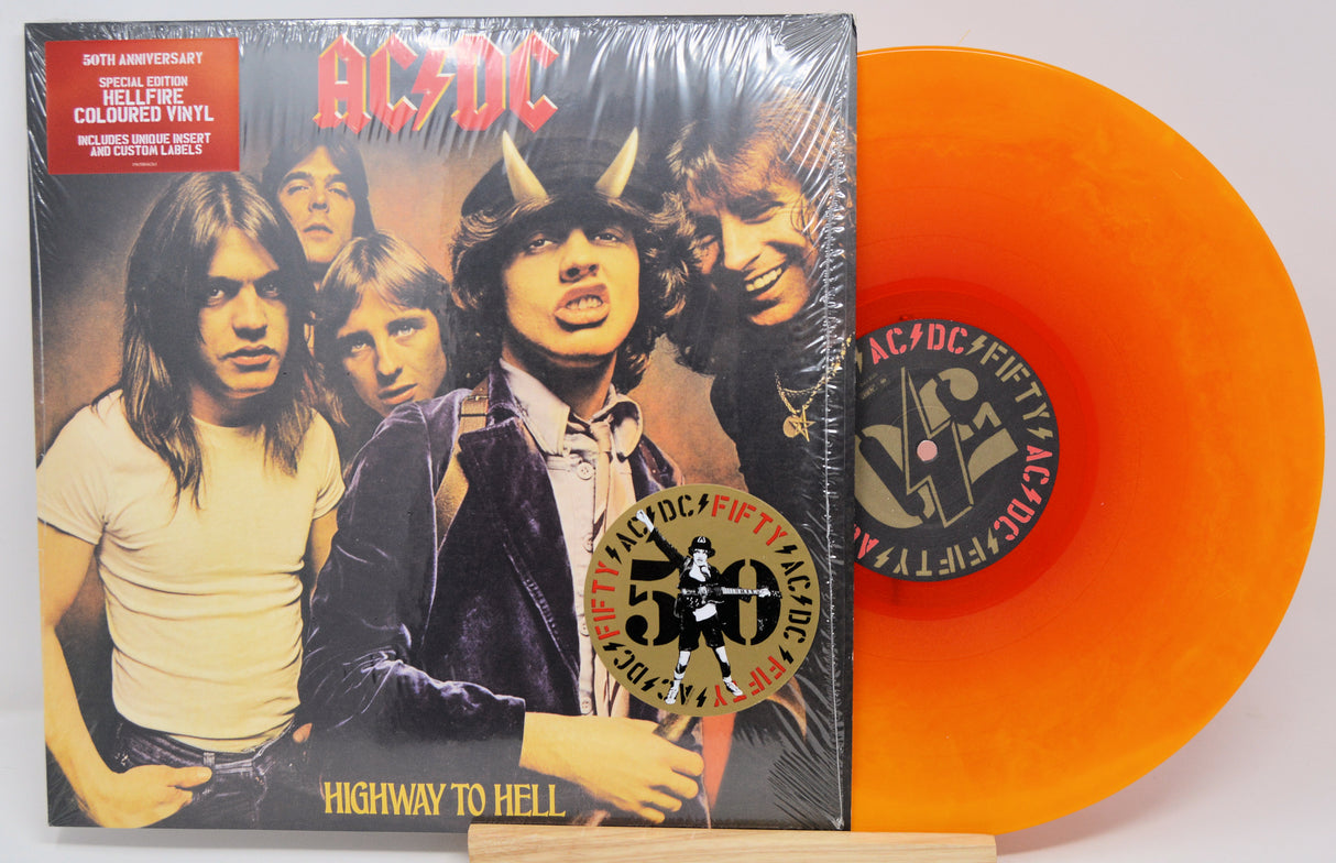 AC/DC 'Highway to Hell' vinyl record with orange disc and cover featuring band members.