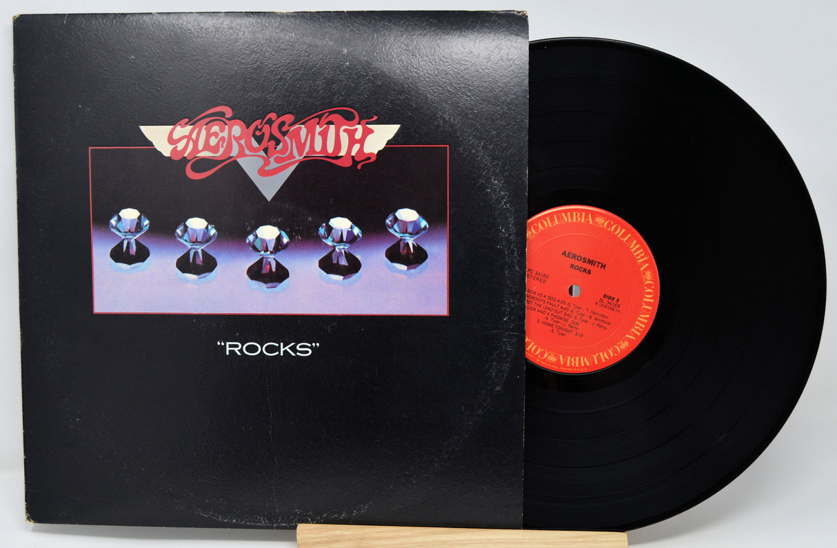 Vinyl record and cover with 'Rocks' album art on a white background