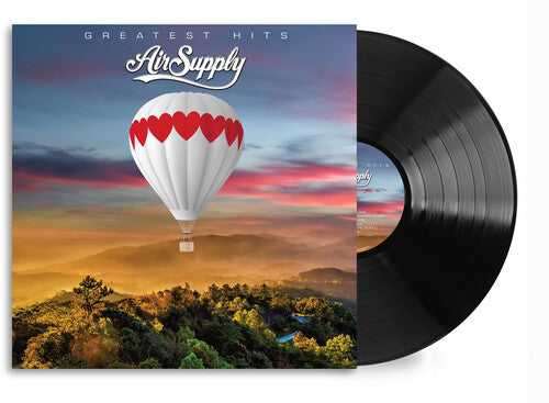 A vinyl record of Air Supply's greatest hits with an album cover featuring a hot air balloon and a sunset or sunrise landscape.