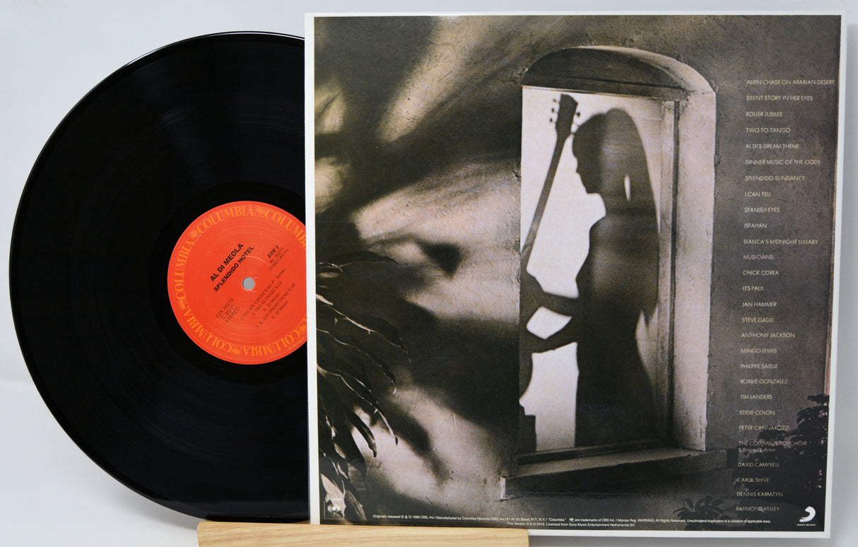 A vinyl record partially pulled from its sleeve, showing the black record with a bright orange center label and the printed album cover behind it. The cover features a monochrome photo of a woman holding a stringed instrument in a doorway, with tracklist text along the right side.