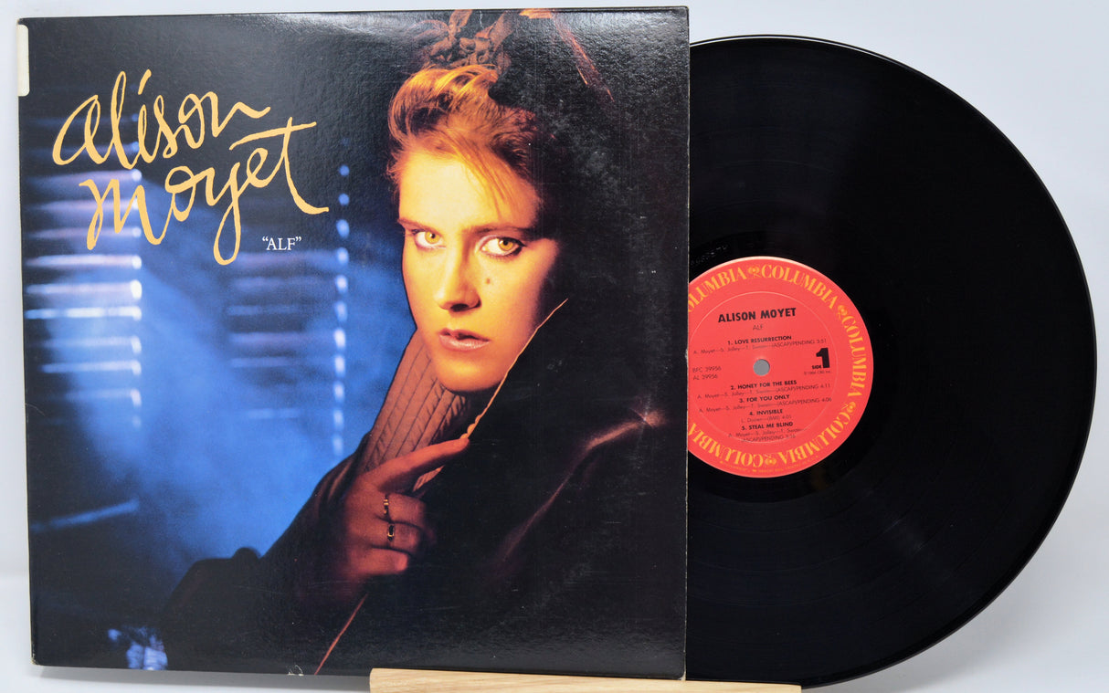 Vinyl record with cover featuring a person, on a light gray background