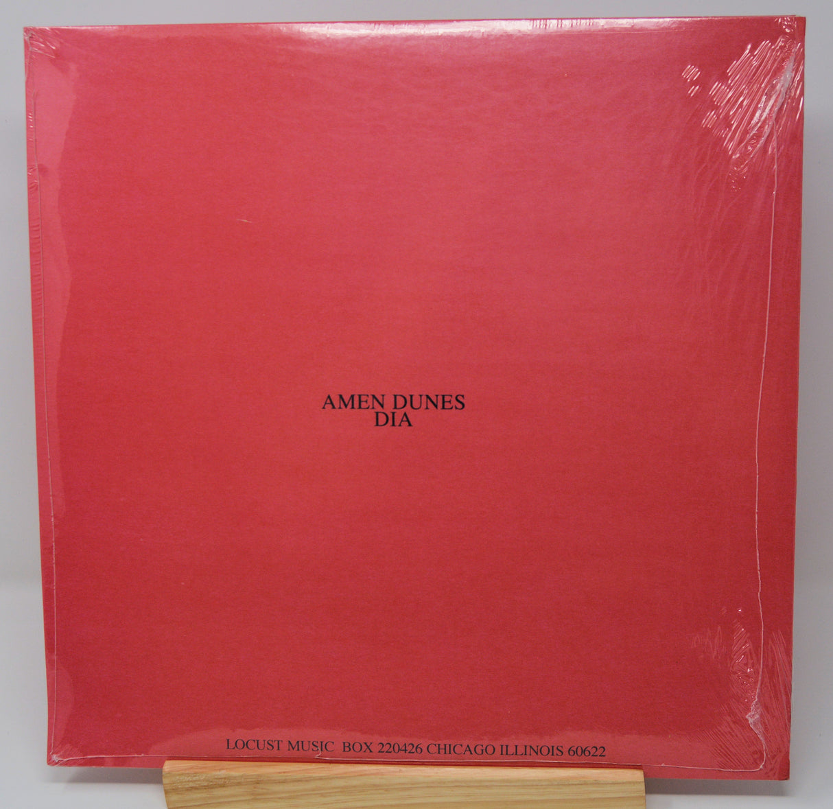 A red vinyl record cover featuring a black and white image of a person's face superimposed on a red background with the text 'DIA' at the top.