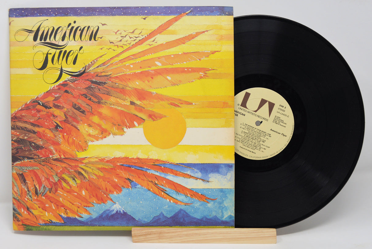 Used vinyl record of American Flyer with a yellow and blue cover featuring an eagle graphic. The record is labeled with 'RCA' and has tracklisting for 'The Loose Connection' and 'Say You'.