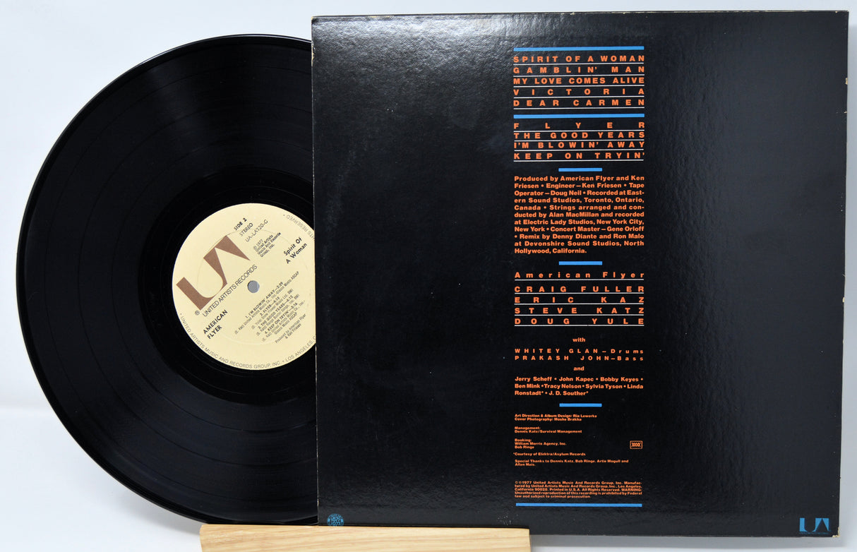 Vinyl record with cover displaying text on a light gray background