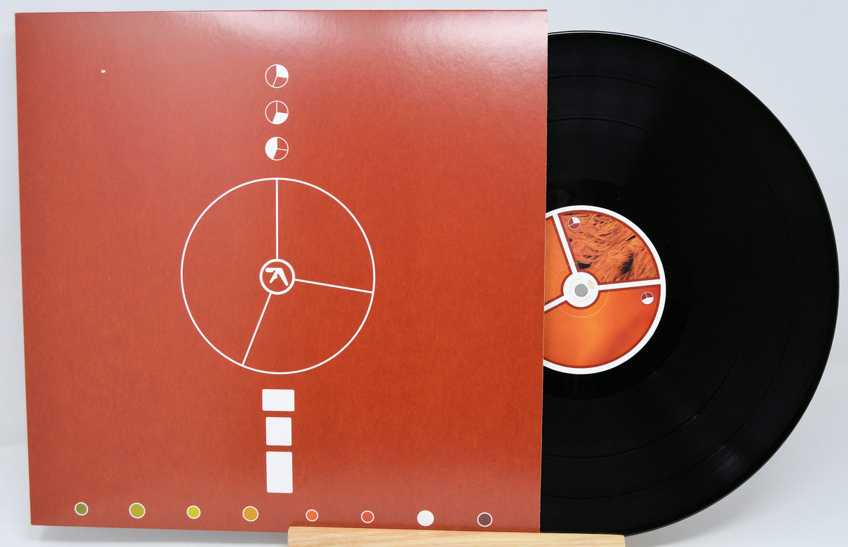 Vinyl record with a red cover featuring white graphics on a light gray background