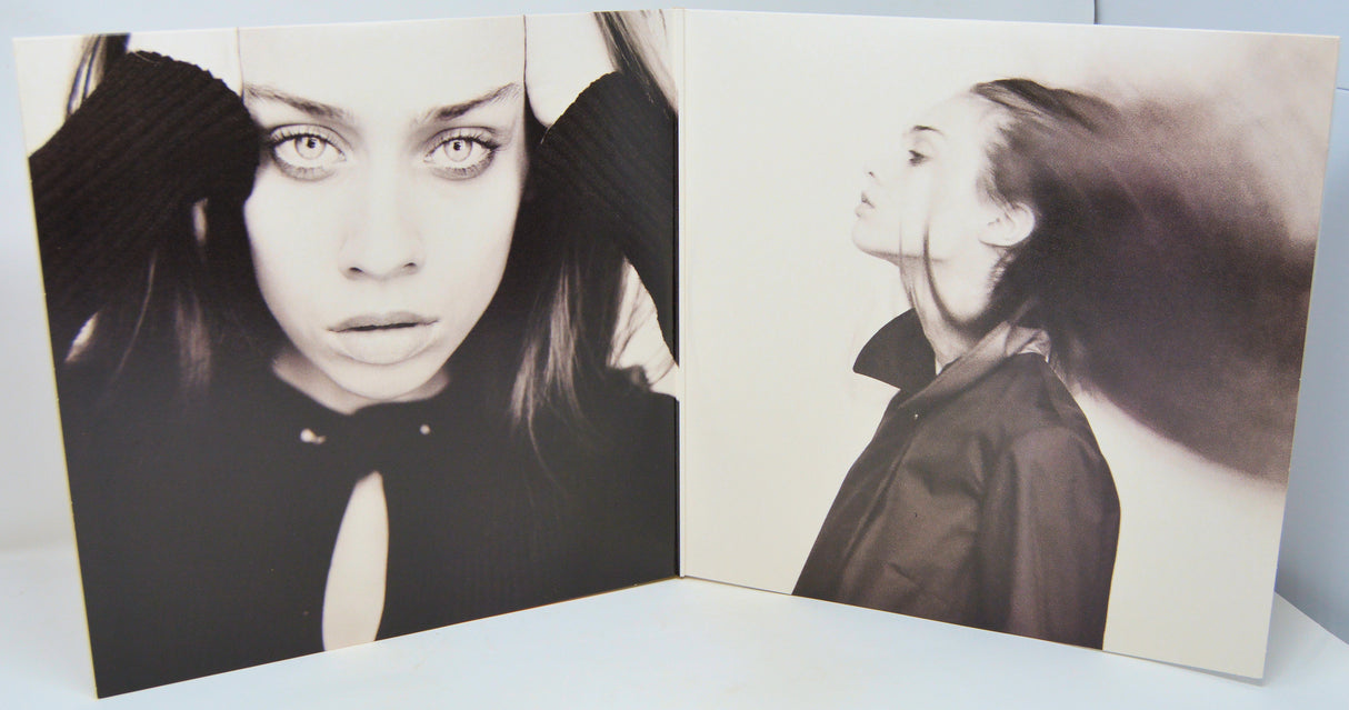 Album cover with black and white portraits of a woman on a light blue background