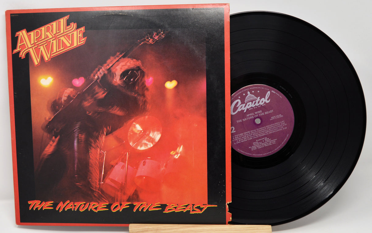 Vinyl record with cover featuring a guitar and red lighting, labeled 'April Wine The Nature of the Beast'.