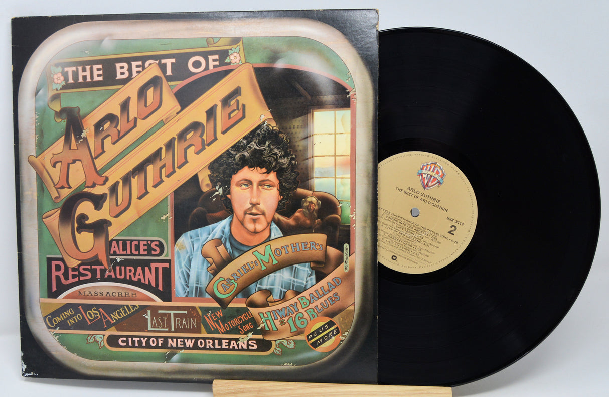 Vinyl record with cover featuring Woody Guthrie and text on a white background