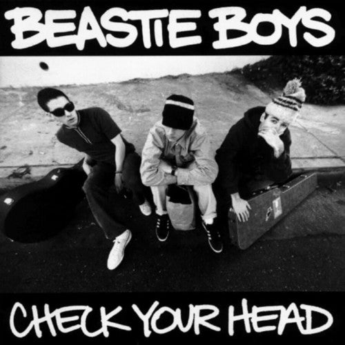 Album cover of 'Check Your Head' by Beastie Boys featuring three band members sitting on a car.