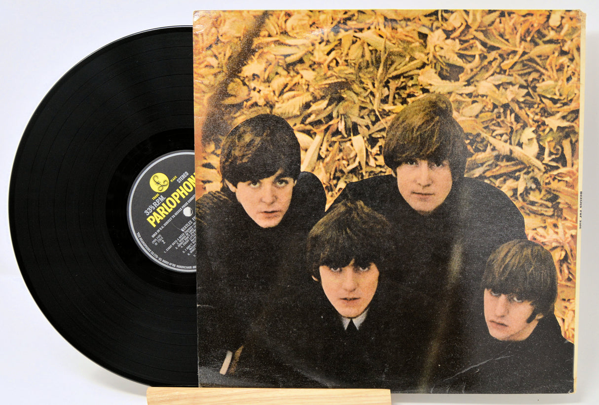 Vinyl record with back cover featuring The Beatles against a textured background.