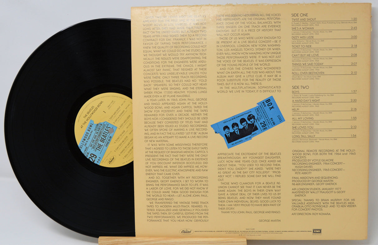 Vinyl record with cover displaying text and a blue label on a white background