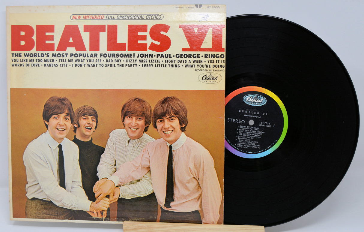 Vinyl record with cover featuring The Beatles on a light gray background