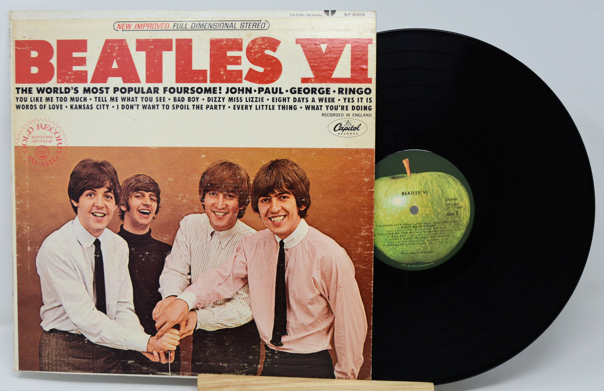 Vinyl record and cover of 'The Beatles VI' album on a light gray background