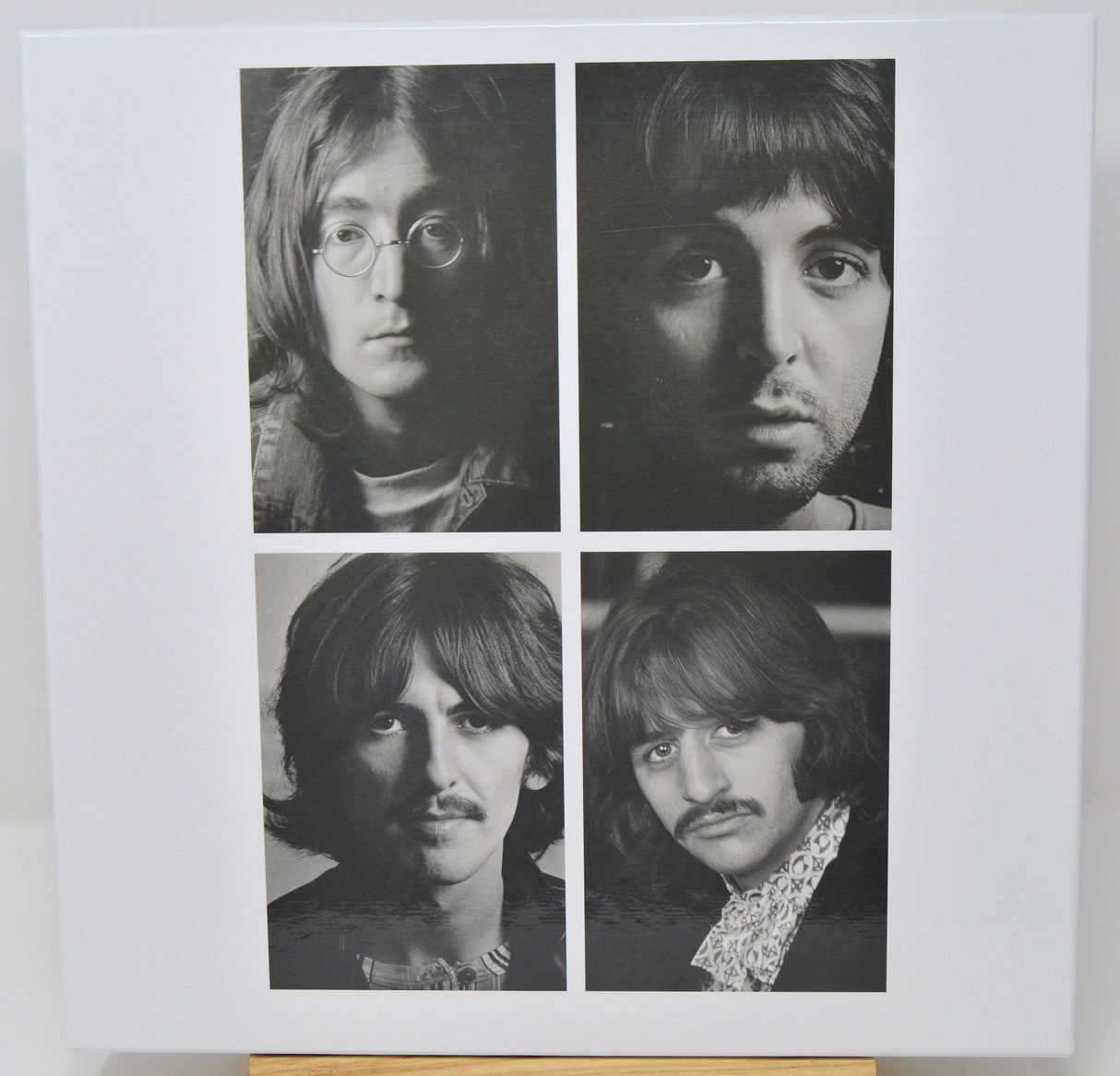 Black and white portraits of four individuals arranged in a 2x2 grid on a light background.