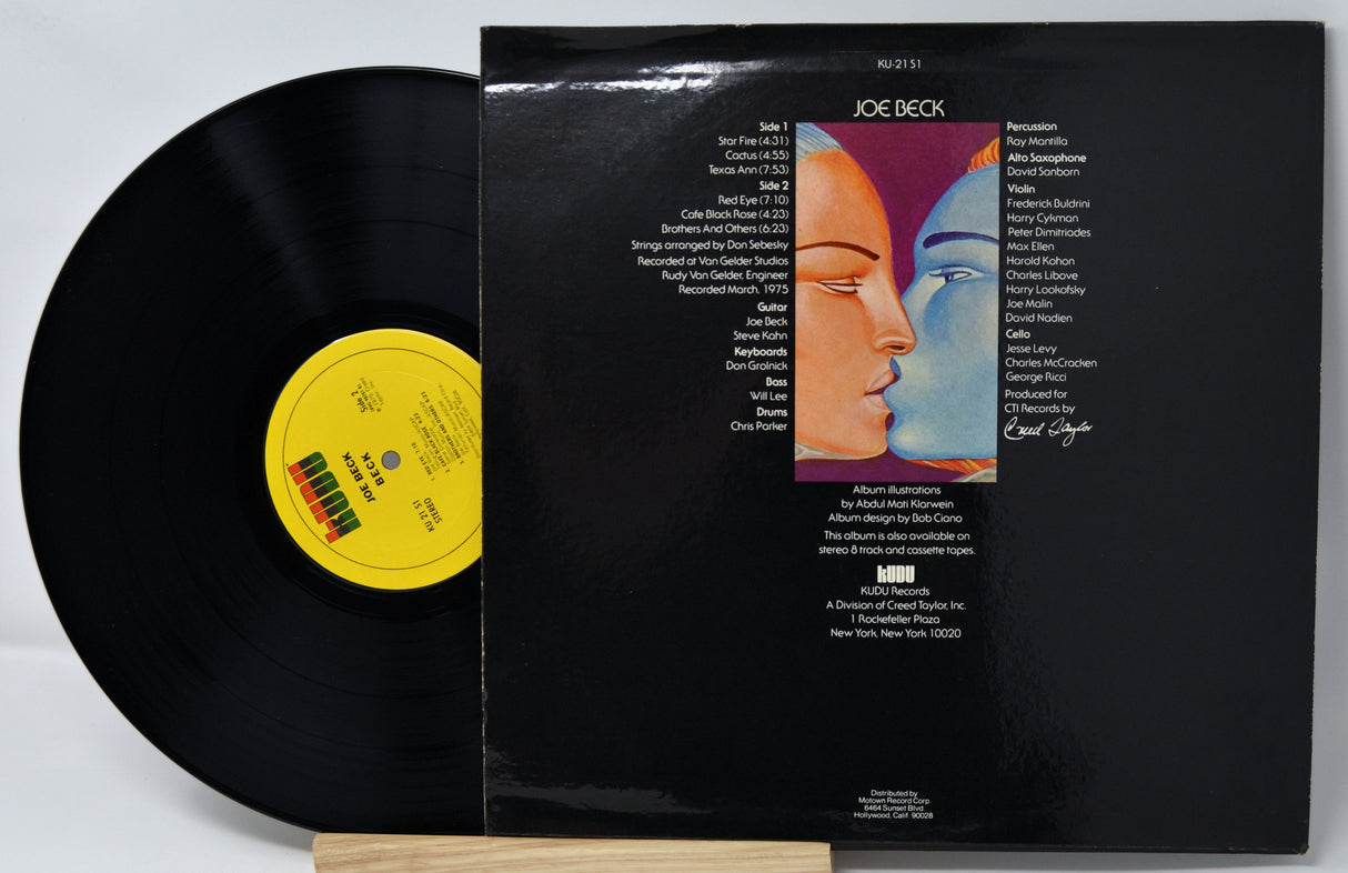 Vinyl record with a colorful cover featuring a face design on a gray background