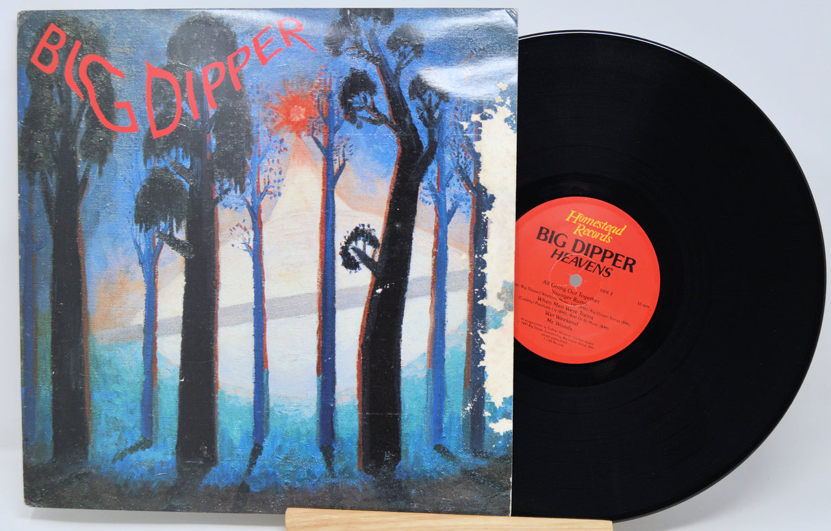 Vinyl record with cover featuring artistic design of trees and a person, on a light gray background.
