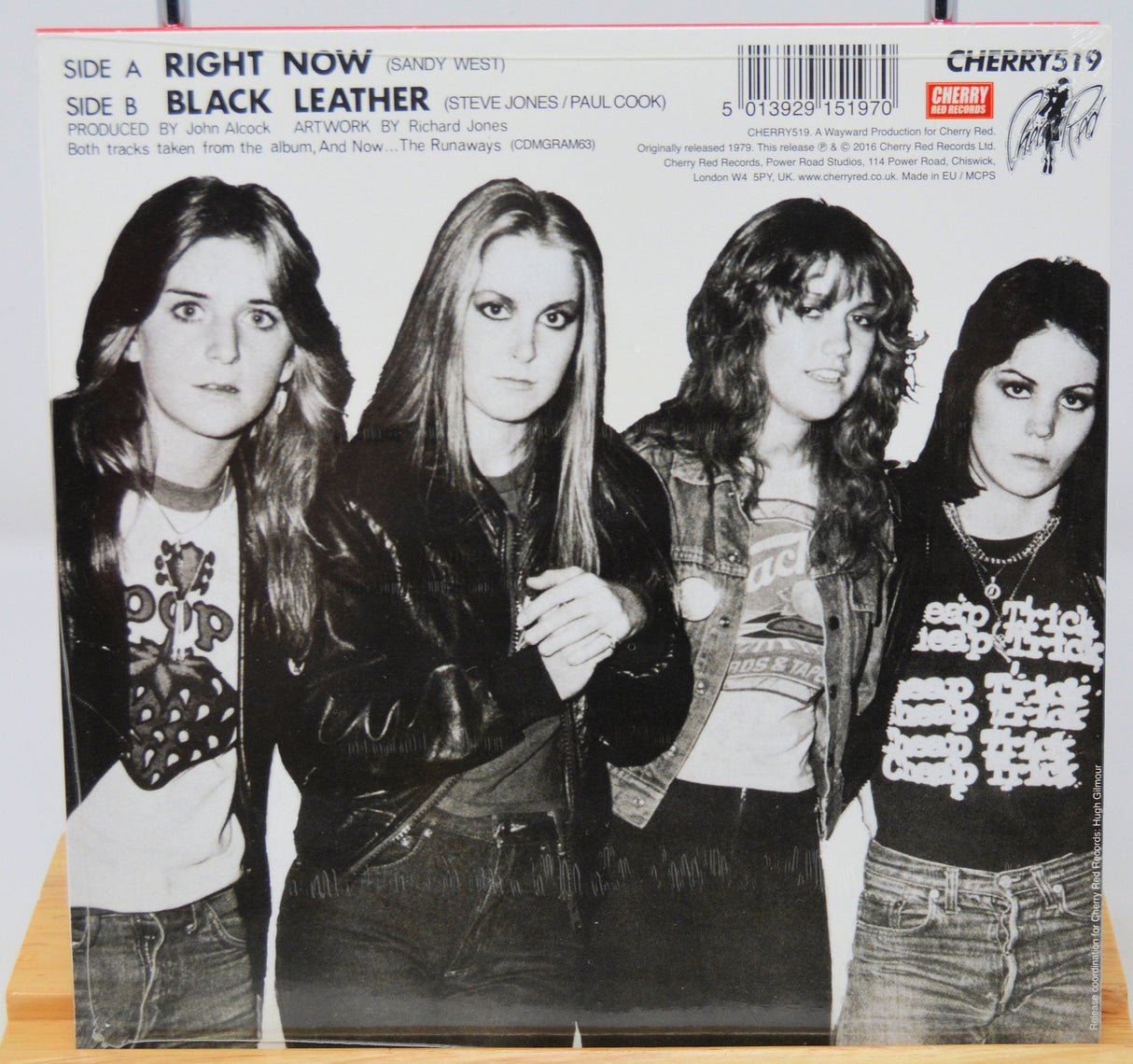 Back cover of The Runaways Right Now / Black Leather 7- vinyl single featuring a black and white group photo of the band.