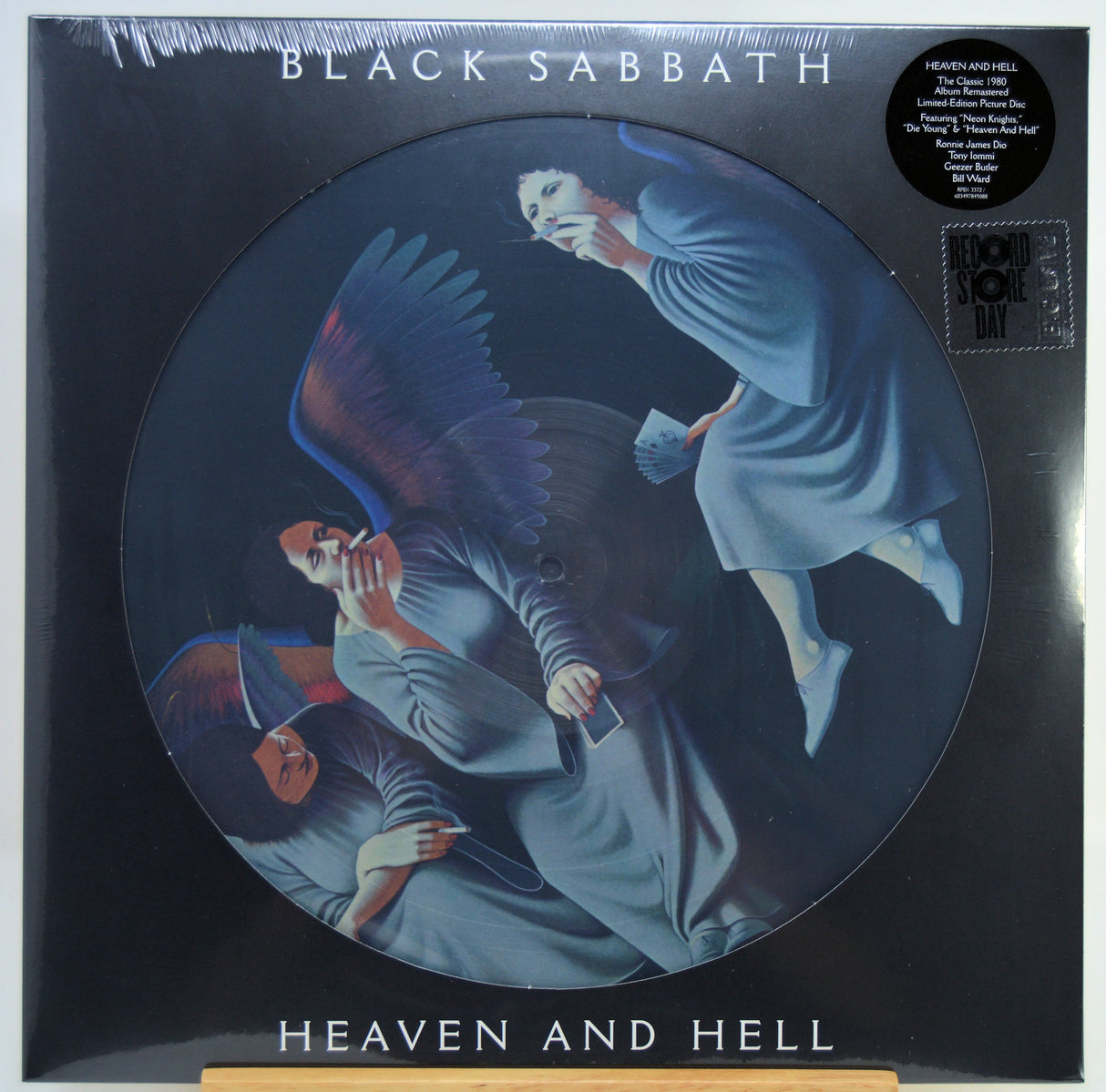 Black Sabbath 'Heaven and Hell' picture record vinyl LP in its original shrink-wrap packaging, featuring a circular printed cover with a dark illustration of three angel figures in blue-gray robes.