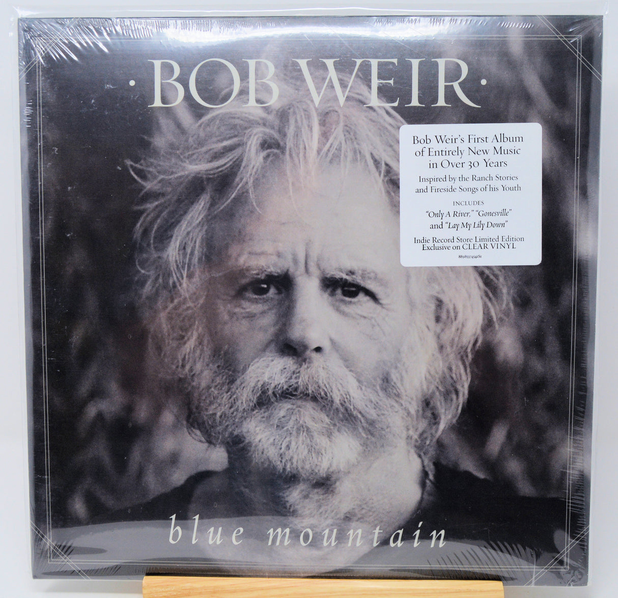 Bob Weir's 'Blue Mountain' vinyl record album, sealed in its original plastic shrink wrap. The cover features a black and white portrait of Bob Weir with his name in large white letters at the top and the album title at the bottom.