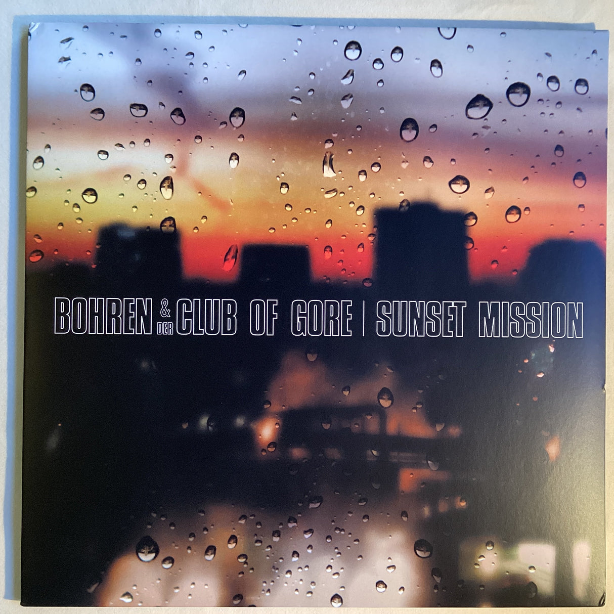 Front cover of Bohren & der Club of Gore Sunset Mission with city sunset and raindrops