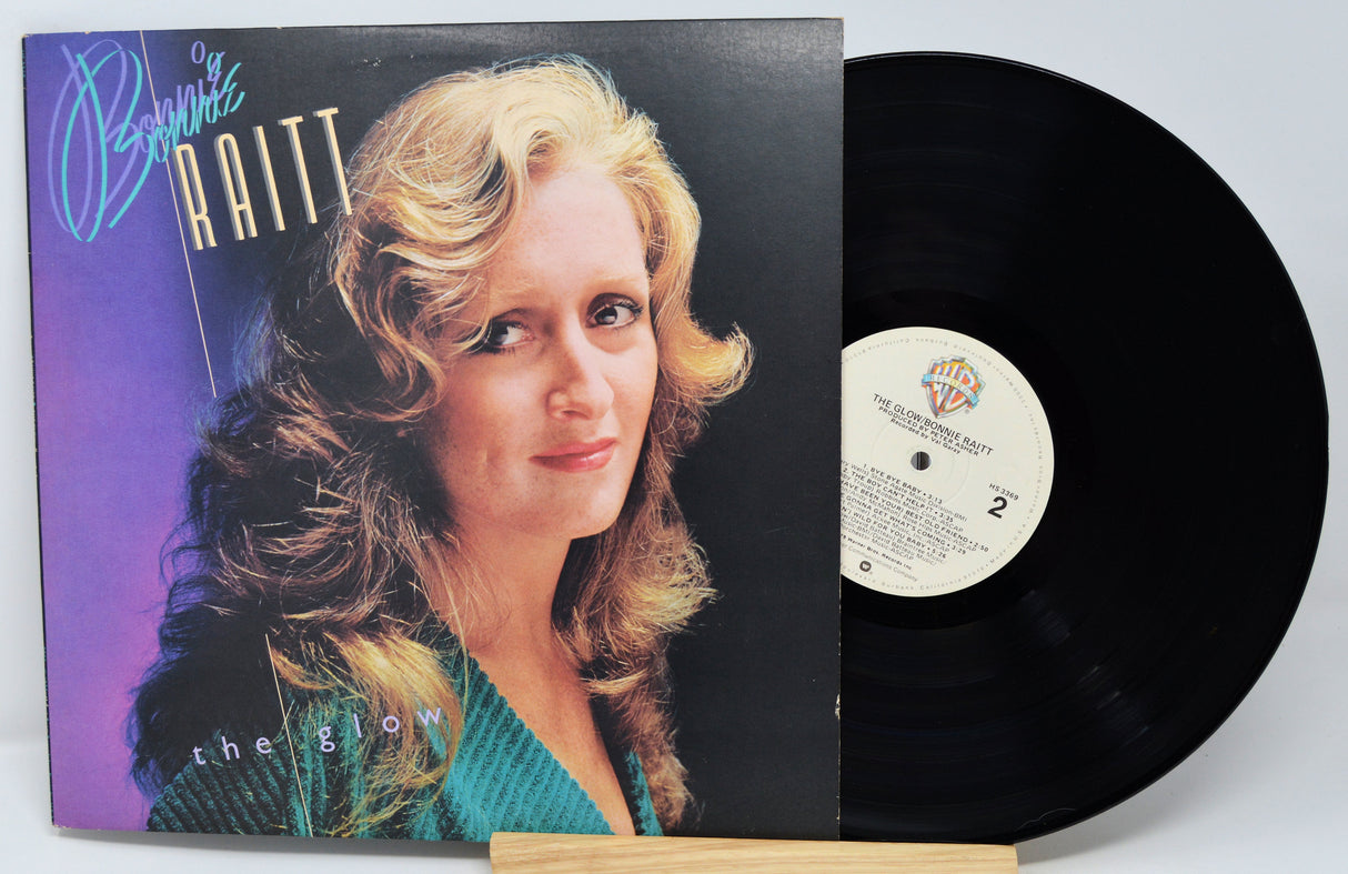 Vinyl record with cover featuring a woman's face and album title 'The Glow' by Bonnie Raitt.