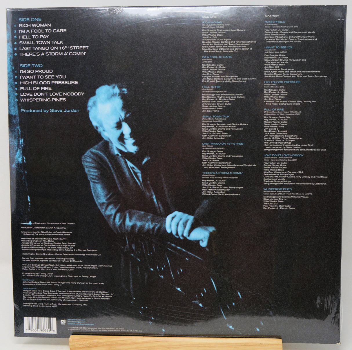 The back cover of a vinyl record sleeve for Steve Jordan's album 'Side Two', displayed on a wooden stand against a white background.