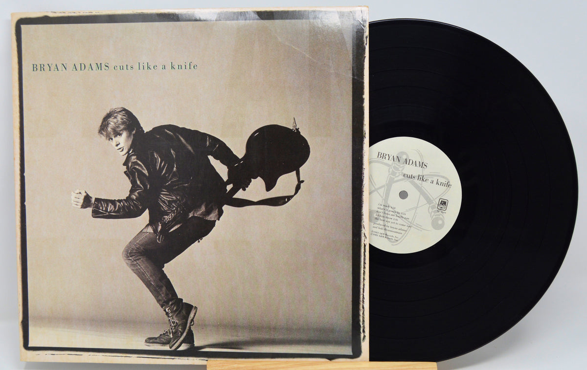 Vinyl record with cover featuring a silhouette of a person playing guitar, on a white background.