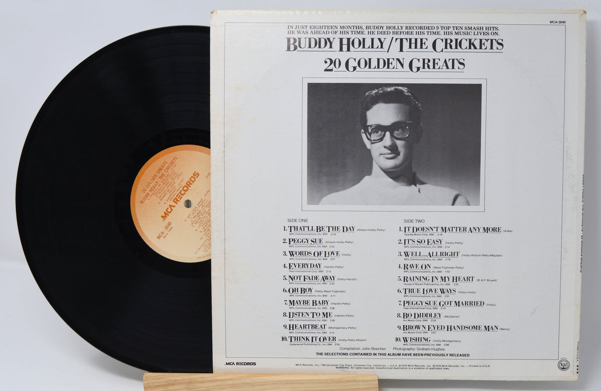 Buddy Holly vinyl record titled '20 Golden Greats' and the back cover with a photo of him and text for the song titles and credits.