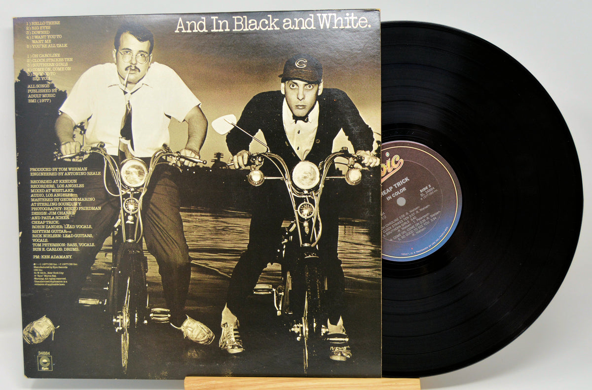 Vinyl record with cover art showing two men on bicycles.