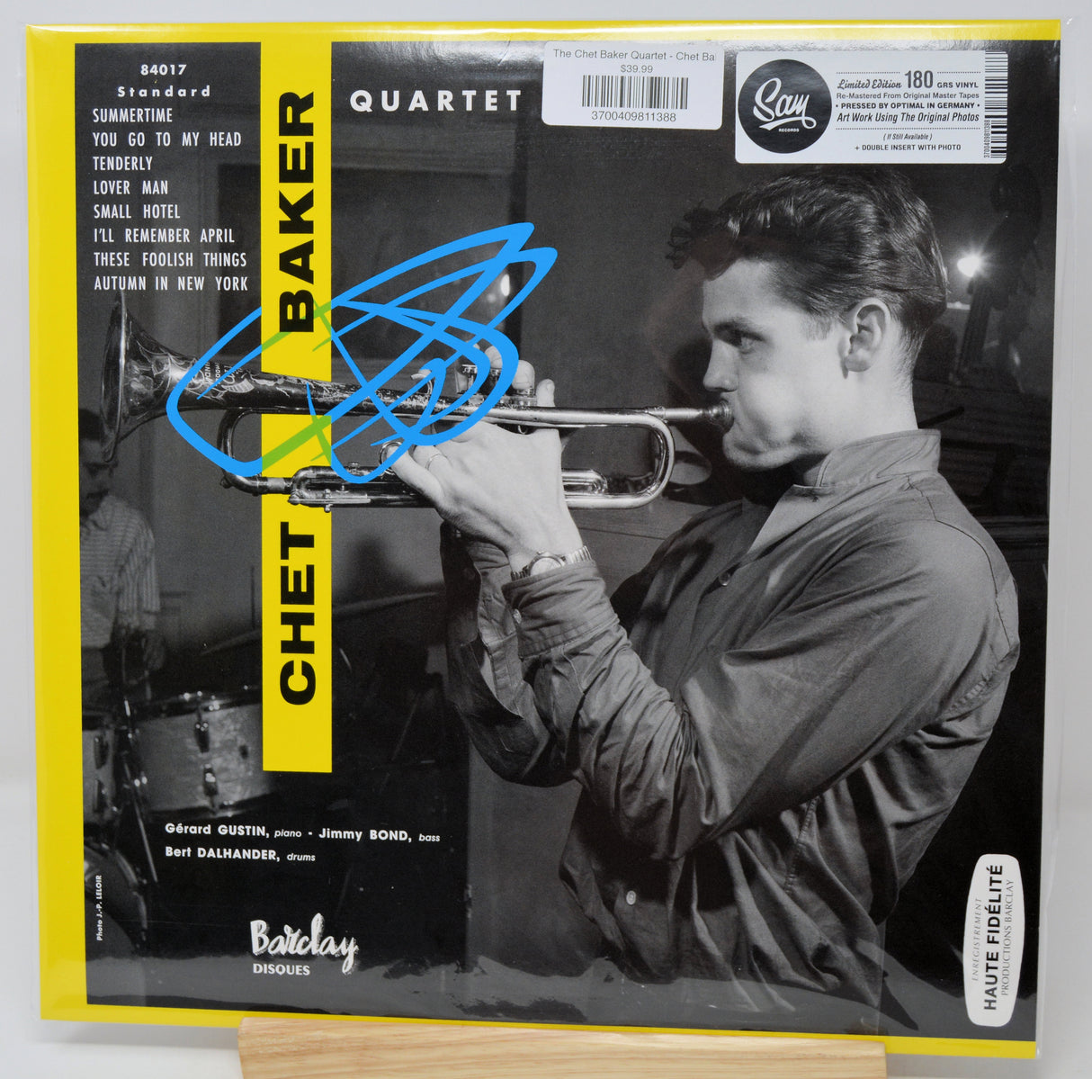 Chet Baker Quartet vinyl record album cover on a light background, featuring a black-and-white photo of Chet Baker playing trumpet, a yellow vertical 'CHET BAKER' label, and a blue scribble across the upper left.