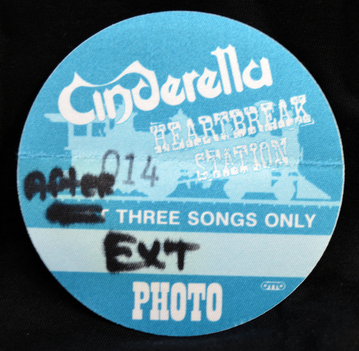 A circular blue and white fabric patch featuring the text 'Cinderella Heartbreak' and 'After Three Songs Only Ext Photo' with black spray-paint style markings, shown on a black background.