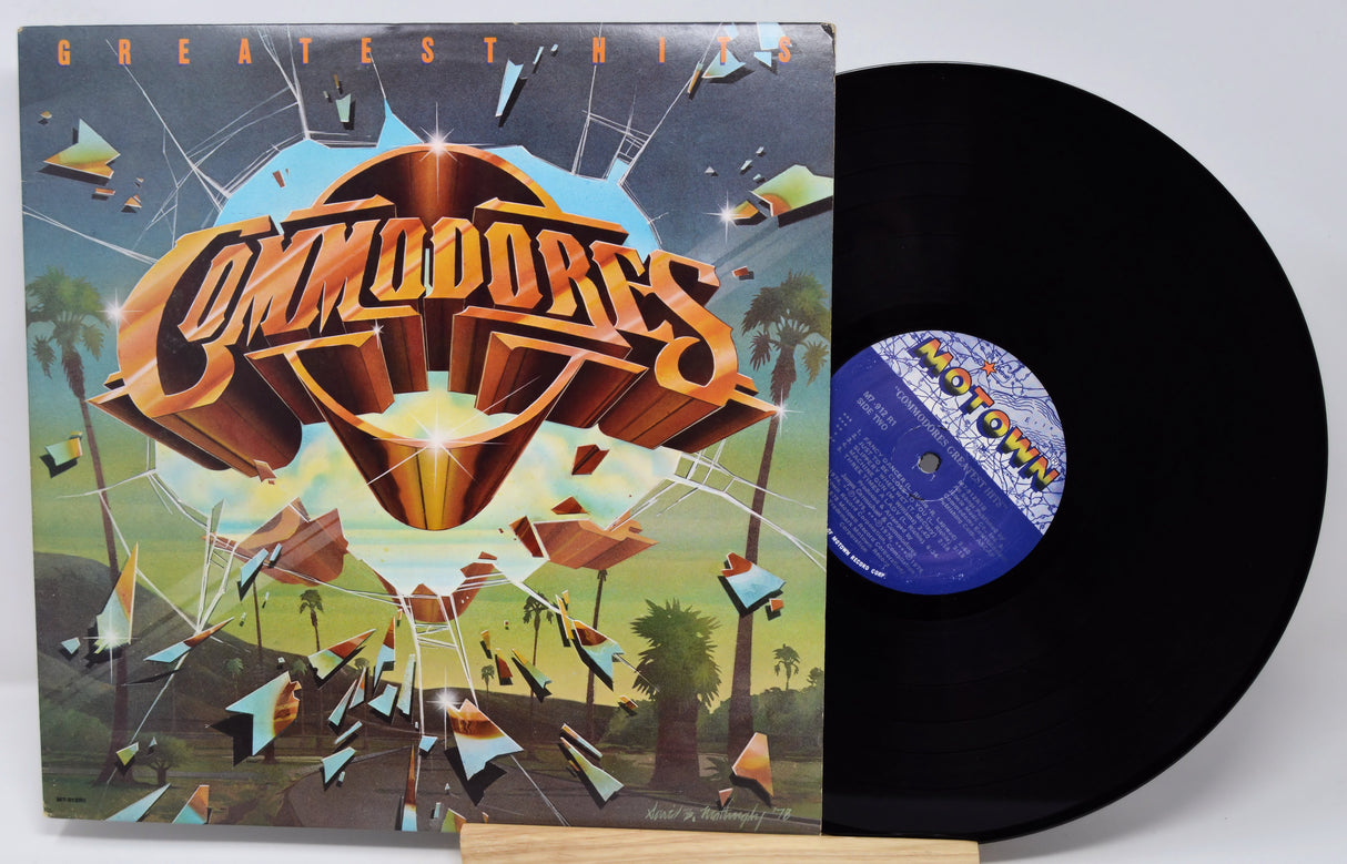 Vinyl record with cover featuring 'Commodores' artwork on a white background