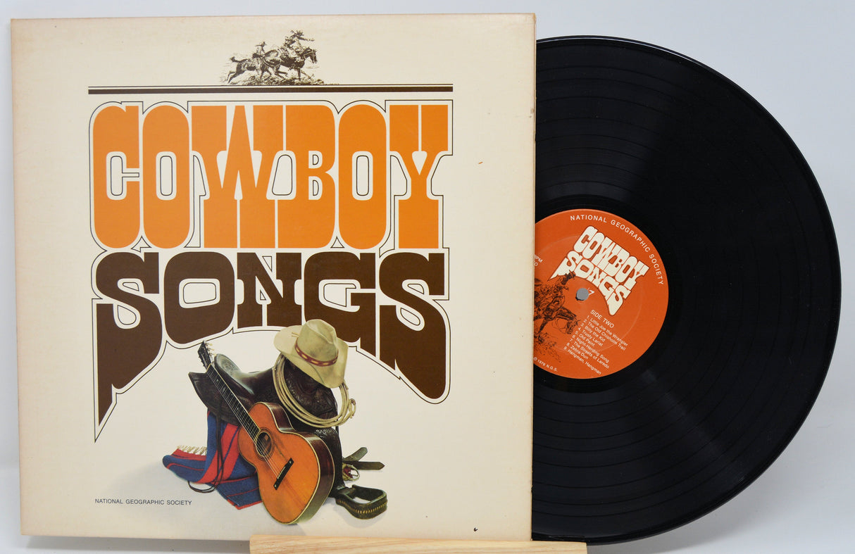 Front cover of Cowboy Songs vinyl album with guitar, cowboy hat, and western gear