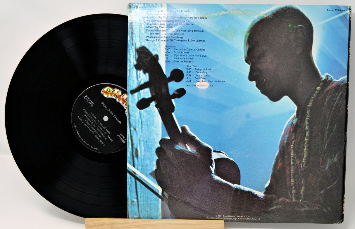 Vinyl record with a blue cover featuring a silhouette of a person playing a stringed instrument.