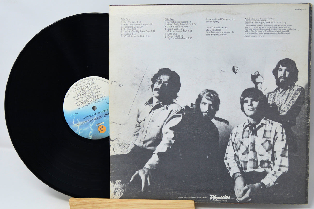 Vinyl record with a black cover featuring a group of people and a white label.