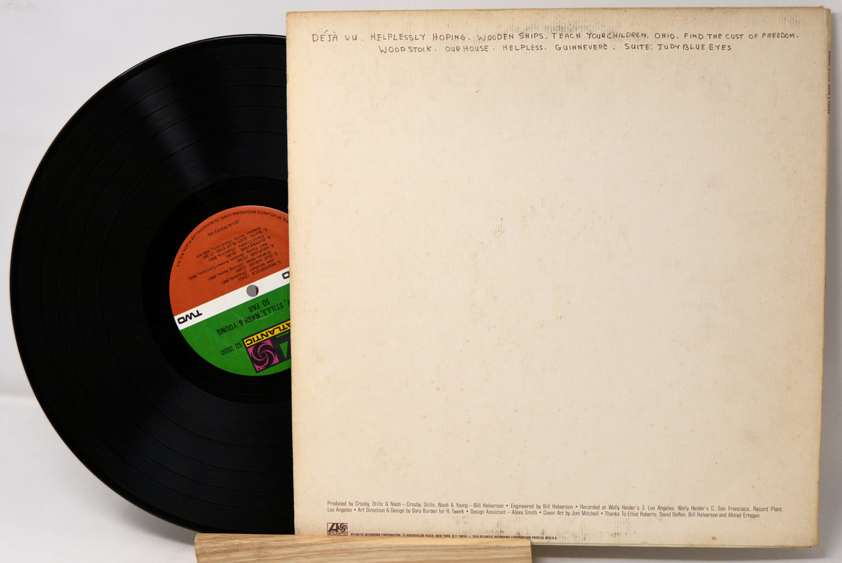 Vinyl record with a colorful label and its cover on a light background