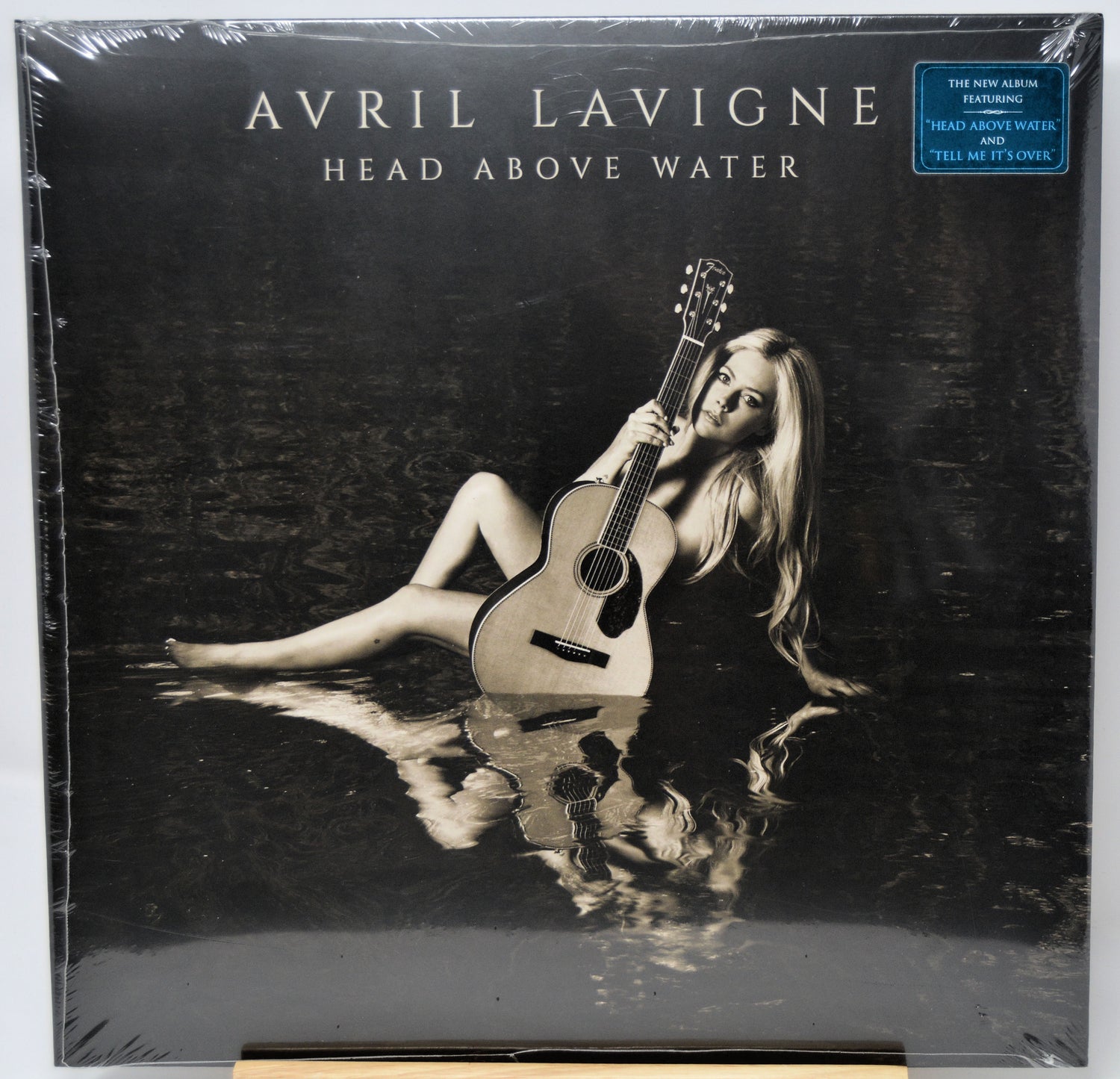 Album cover of 'Head Above Water' by Avril Lavigne with a person holding a guitar underwater.