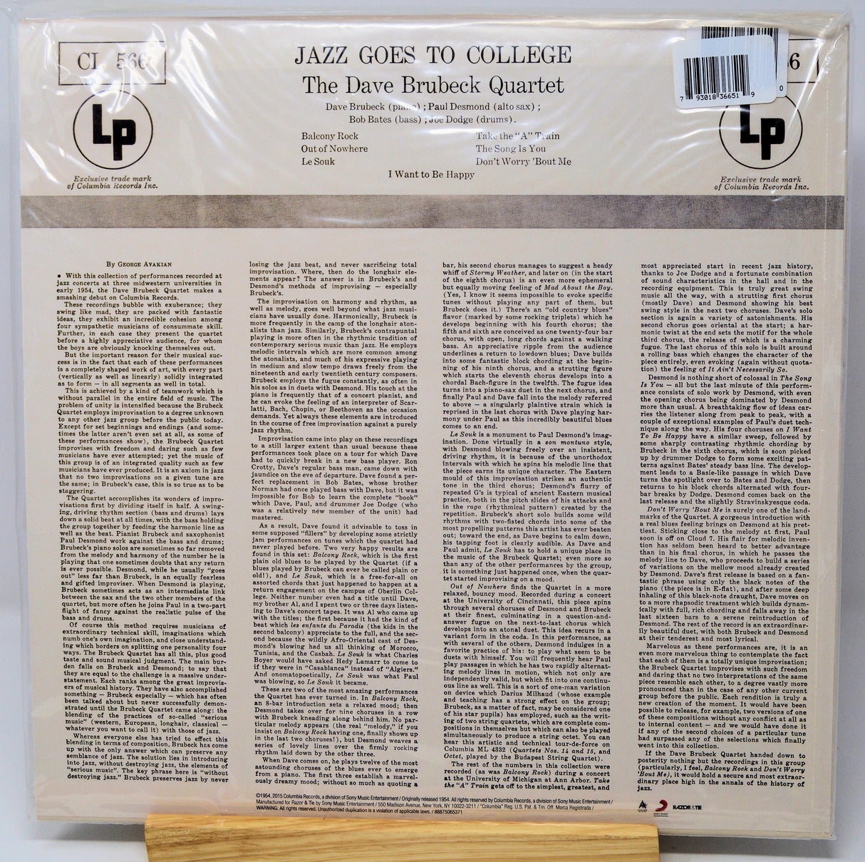 The back cover of a LP vinyl record for 'Jazz Goes to College' by The Dave Brubeck Quartet, wrapped in protective plastic and resting on a wooden display stand.