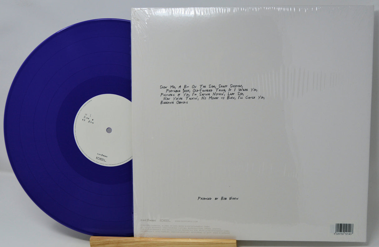 Blue vinyl record with white label and white sleeve on a gray background