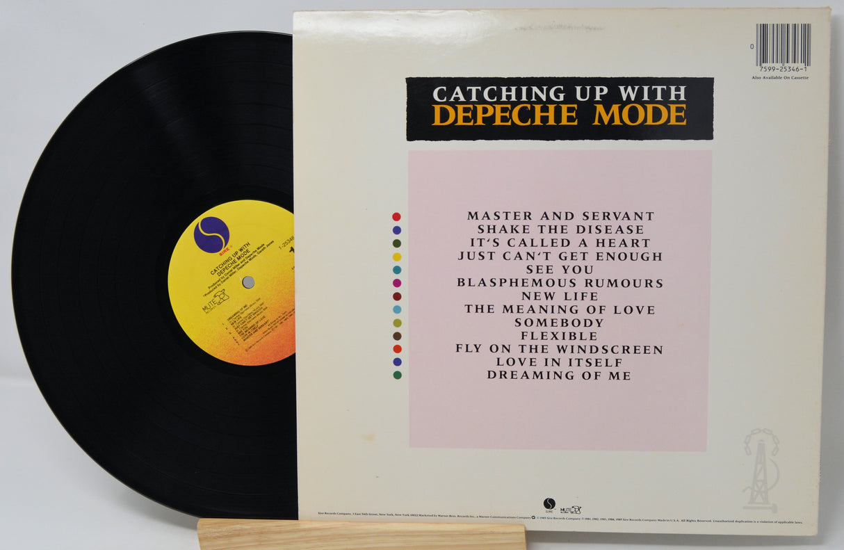 Vinyl record and cover of 'Catching Up With Depeche Mode' on a light gray background