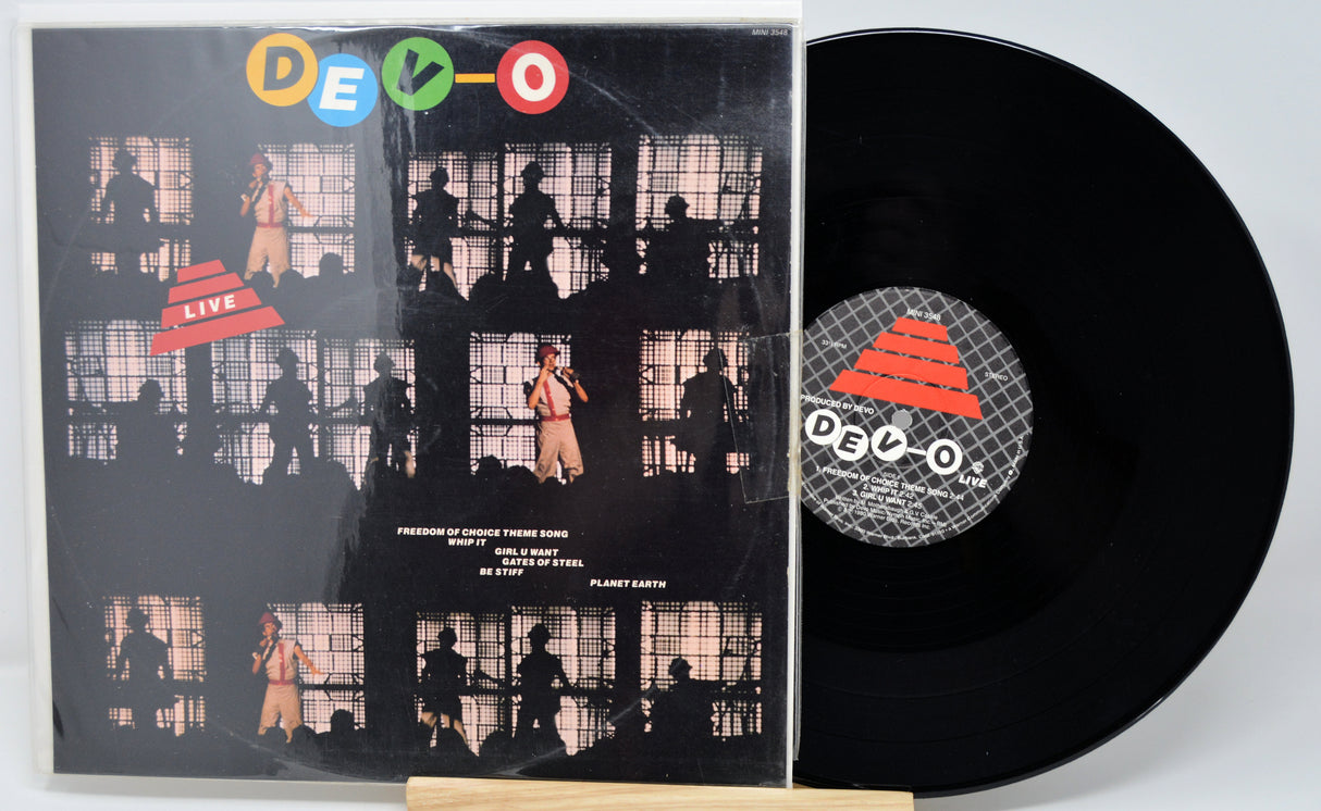Vinyl record with a black cover featuring silhouettes and a visible DEVO logo.