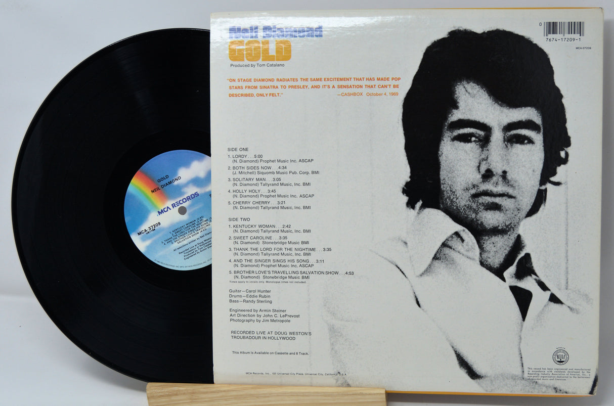 Vinyl record with cover featuring a black and white portrait of a man, rainbow label, and text.