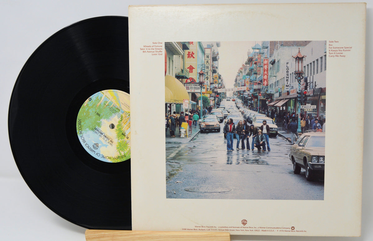 Vinyl record with a cover featuring an urban street scene