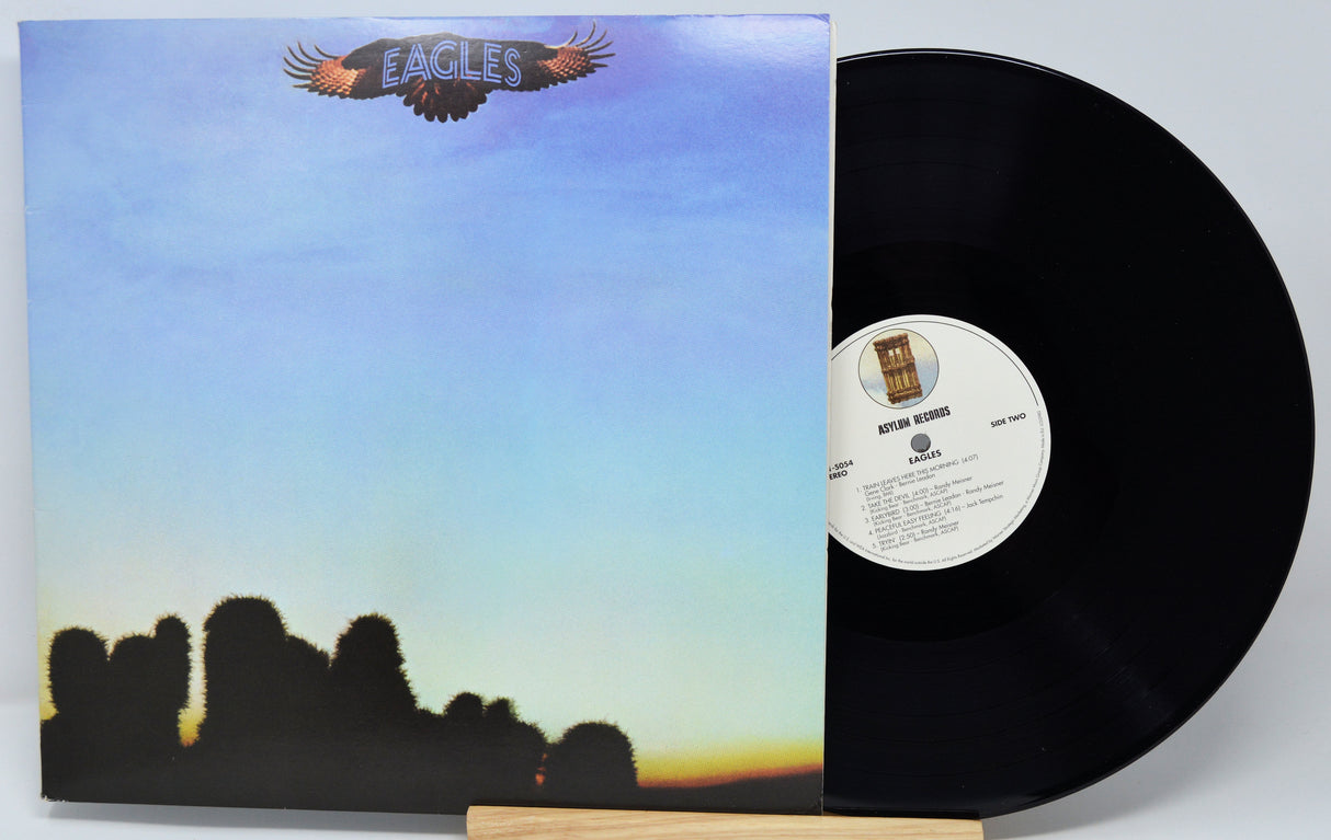 Vinyl record with cover featuring an eagle logo and landscape design.