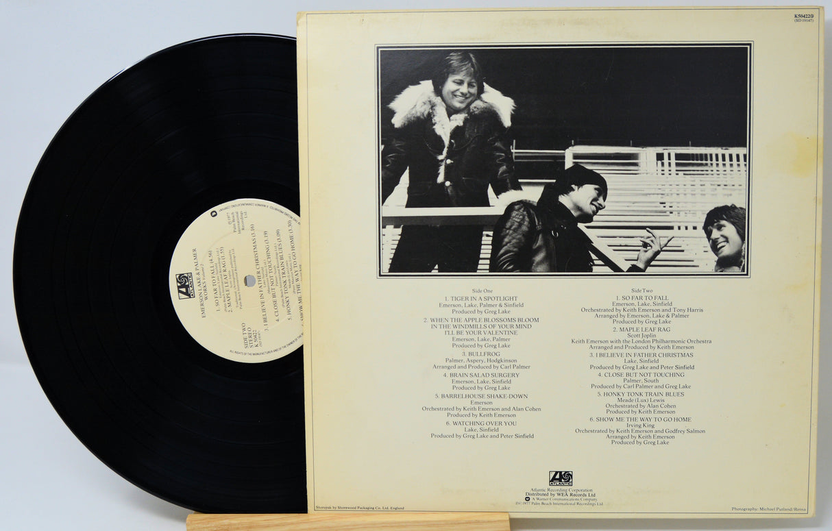 Vinyl record with cover featuring a black and white photo of three people and text.