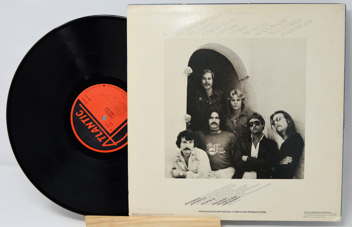 Vinyl record with a back cover featuring a band photo and an orange label on a white background by Firefall titled Luna Sea.