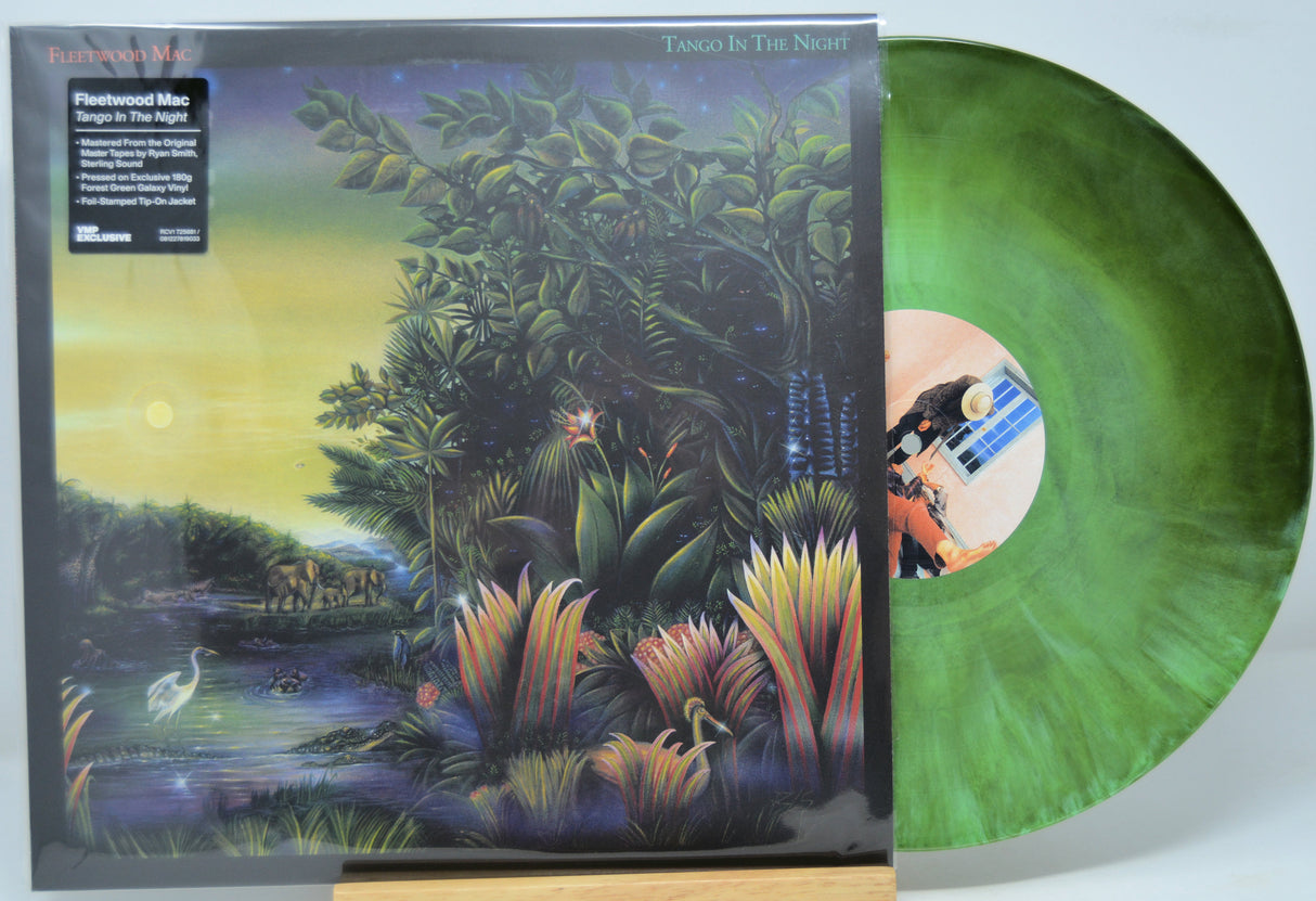 Vinyl record by Fleetwood Mac titled 'Tango In The Night' with a colorful cover and green disc on a white background.
