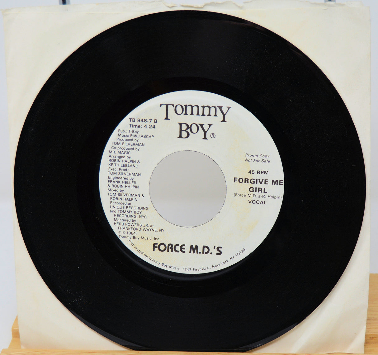 Vinyl record with 'Tommy Boy' label on a white background